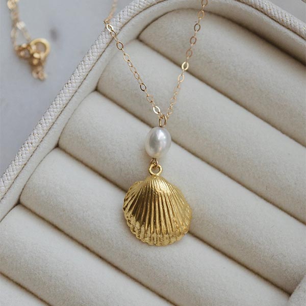 A gold shell necklace by Vanessa Stephens